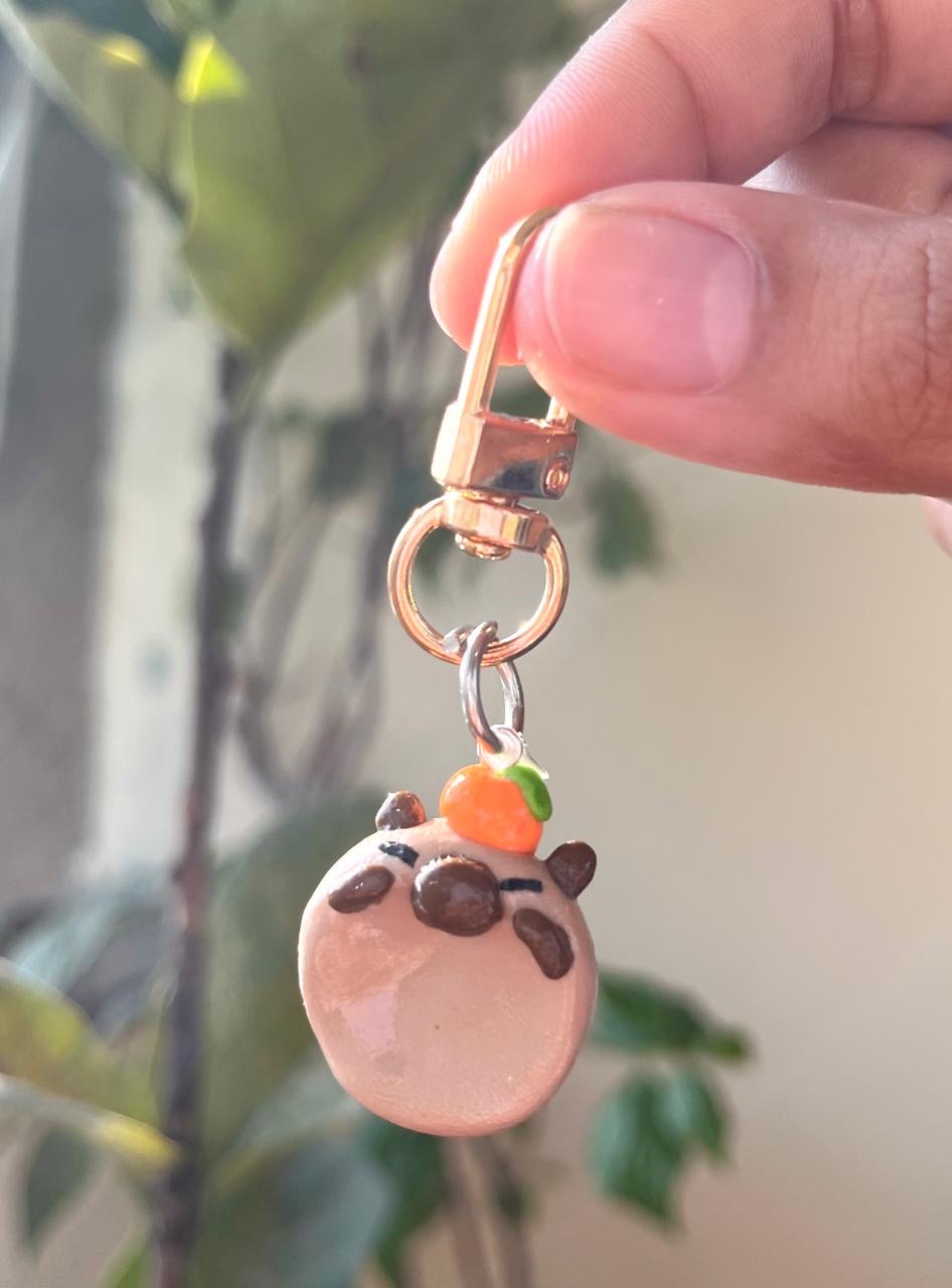 Round pink character charm with a tiny orange detail on top