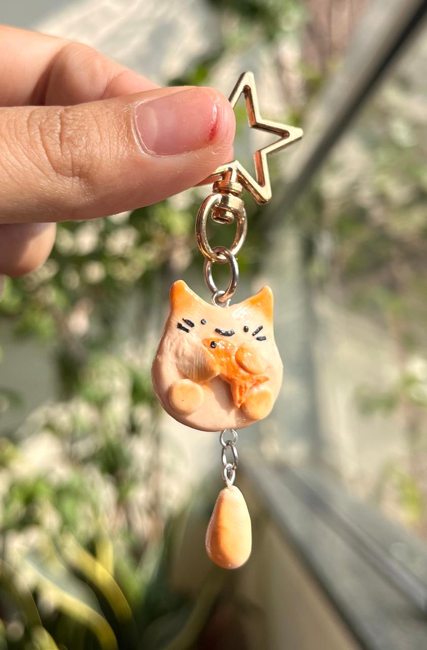 Handmade cat charm holding a little fish