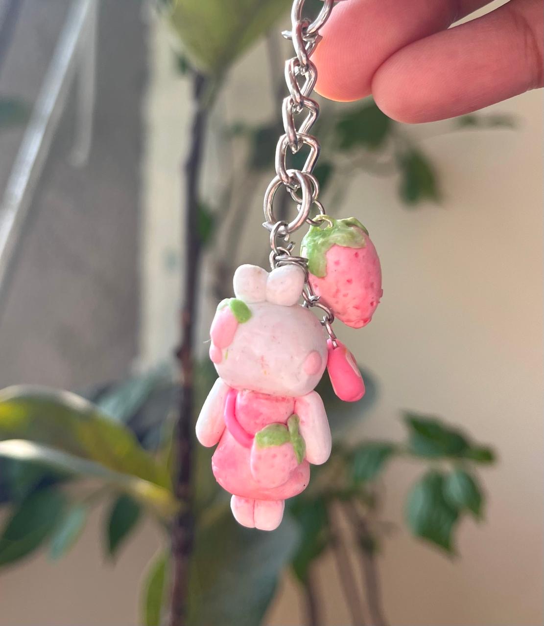 Pink handmade character charm with a strawberry companion